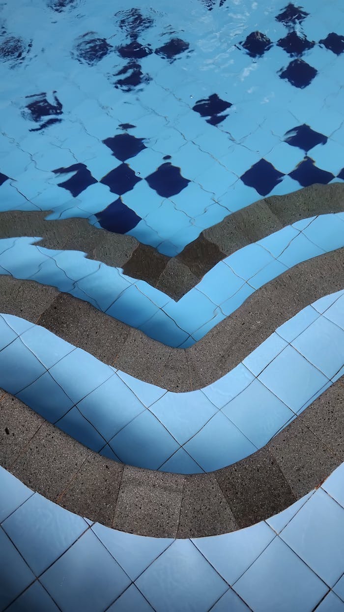 Bold geometric design of swimming pool steps in vivid blue tones.